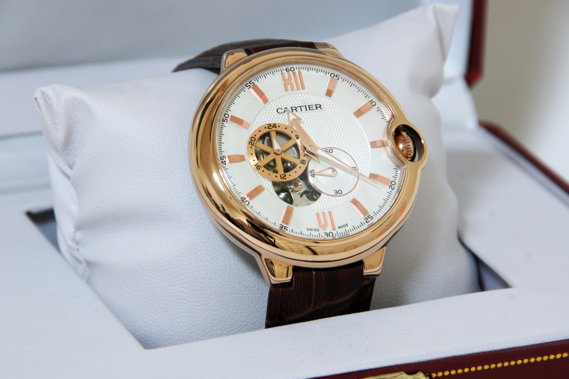 Roségouden merkhorloge met lichte wijzerplaat in een geopende doos
